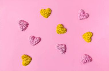 Dört sarı ve beş pembe kalp pastel pembe arka planda bir kareye yerleştirilmiş. Sevgililer Günü bayrağı ya da kartı için en az romantik konsept. Nişan için sanatsal tasarım ya da düğün davetiyesi. Düz yatıyordu