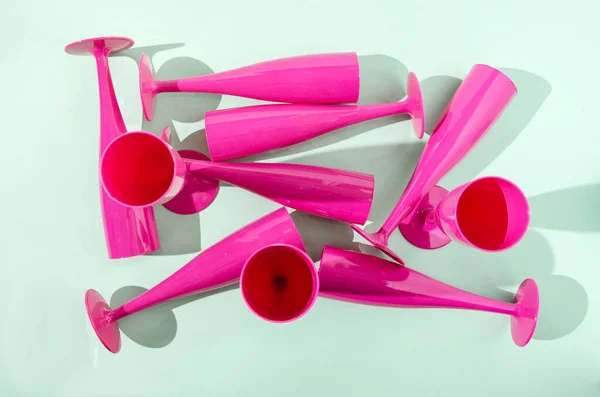 Pastel yeşil arka planda Magenta şampanya bardakları. Sevgililer Günü afişi, doğum günü partisi ya da düğün kutlaması için yaratıcı bir konsept. Düz yatıyordu.
