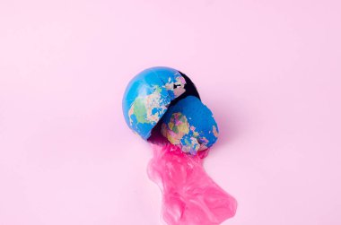 Pembe arka planda fuşya salgısı olan ezilmiş bir küre. Ukrayna Rusya çatışması ve savaş mağdurları için yaratıcı bir kavram