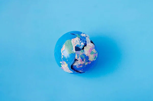 Globe Est Écrasé Sur Fond Bleu Concept Créatif Pour Éditorial — Photo