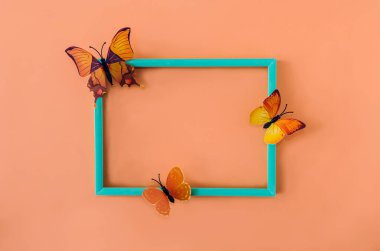 Turuncu arka planda turuncu ve sarı kelebekli mavi-yeşil çerçeve. Zarif bahar kartı, afiş ya da reklam için yaratıcı tasarım. Düz yatıyordu. Boşluğu kopyala