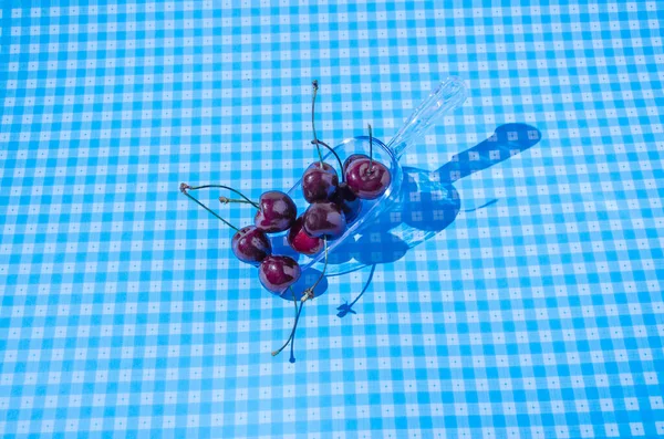 Φρέσκα Βιολογικά Κεράσια Πλαστικό Κουτάλι Διάστικτο Μπλε Και Λευκό Φόντο — Φωτογραφία Αρχείου
