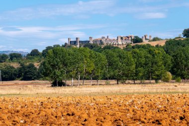 Küçük bir ortaçağ kasabası olan Monteriggioni, güneşli bir yaz gününde Francigena yolundan gökyüzüne yükselir.