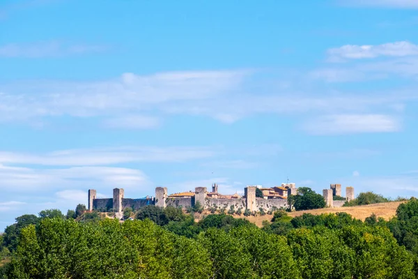 Küçük bir ortaçağ kasabası olan Monteriggioni, güneşli bir yaz gününde Francigena yolundan gökyüzüne yükselir.