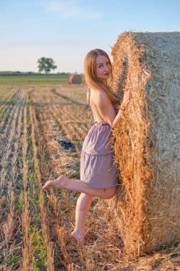 Samanlıkta şapkalı bir kız.