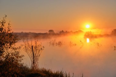 Gölün üzerinde sisli gün doğumu