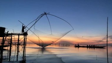 Altın gökyüzü manzaralı kare dalış ağıyla balıkçı