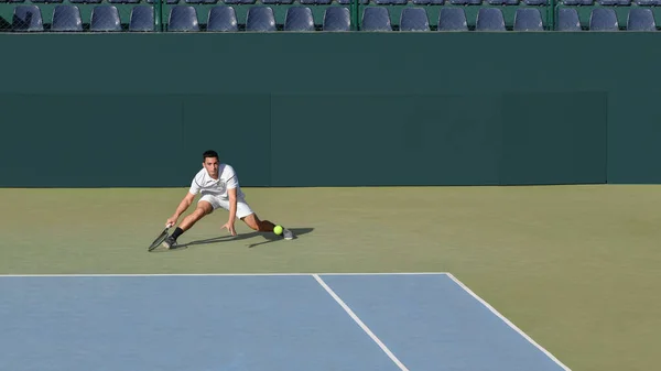 Profesyonel tenisçi topa maçta bakar ya da sert tenis kortunda pratik yapar. Tenis raketi olan genç bir erkek sporcu. Genç tenis sporu. Yeşil arkaplan, afiş, kopyalama alanı