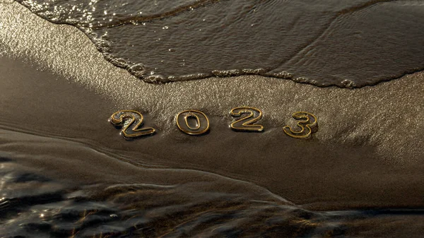 Happy new year 2023 background. 2023 numbers on wet dark golden sand of beach in early morning in dawn light and rolling sea wave. New Year\'s Eve holidays, travel, change, new beginning concept