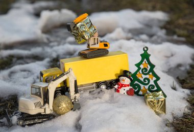 Oyuncak kazıcılar, sarı bir araba, hatıra kardan adam, karda duran altın hediyeler. Noel işi kavramı inşaat şirketlerinde komik selamlar. Seçici odak