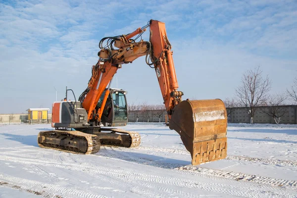 Großer Orangefarbener Kettenbagger Auf Dem Schneebedeckten Boden Der Baustelle — Stockfoto