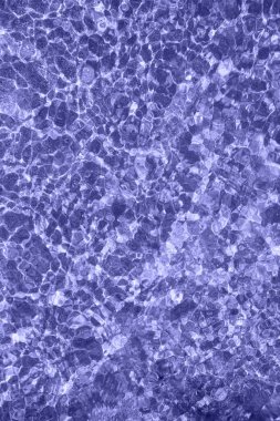 2022 renginde hafif dalgalı su yüzeyi. Yumuşak çizgiler, güneş parlıyor. Soyut arkaplan. Dikey