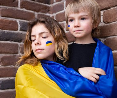 Mavi ve sarı Ukrayna bayrağıyla küçük bir oğlan ve yetişkin bir kız kardeş. Aile, birlik, destek, bakım. Ukraynalılar savaşa karşıdır. Ukrayna 'nın yanında dur.