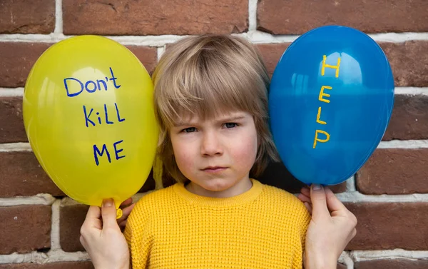 child with blue yellow balloons, with inscriptions, don\'t kill me, help. Fear, despair, drawing attention to military conflict in Ukraine. killings of Ukrainians children during Russian aggression