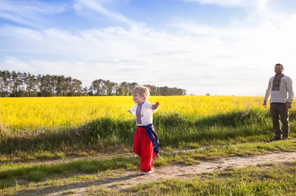 Boy National Ukrainian Clothes Joyfully Runs Flowering Rapeseed Field Dad — стокове фото