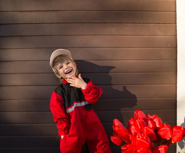 Портрет Смеющегося Летнего Мальчика Красной Форме Кепке Букетом Красных Тюльпанов — стоковое фото