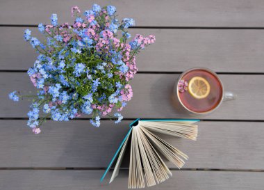 Masada çay fincanı, açık bir kitap ve 