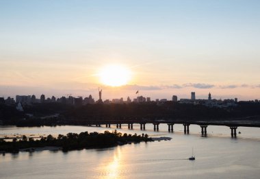 Gün batımında Dnieper Nehri üzerinde köprüsü ve Pechersky bölgesini gören kuş bakışı bir manzarası olan Kyiv. Ukrayna 'nın başkentinde şehir manzarası. Savaşı durdurun.