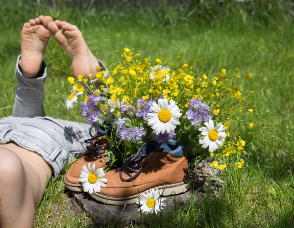 Gołe Stopy Dziecka Leżące Trawie Obok Bukietu Kwiatów Polnych Butach — Zdjęcie stockowe