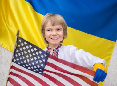 Çocuk Amerikan bayrağını tutuyor, Ukrayna bayrağının arkasında duruyor. Amerika ve Ukrayna 'nın Rusya' ya karşı savaşta dayanışması. Ülkeler arası dostça ilişkiler. Savaşı durdurun. Ukrayna 'nın yanında dur