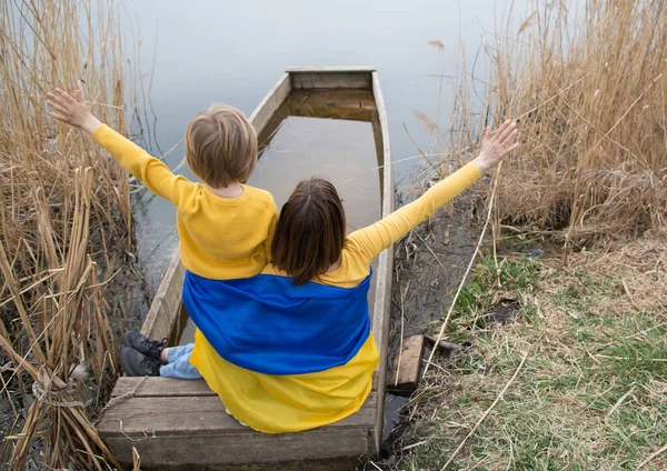 Unrecognizable Boy Woman Sitting Backs Shore Lake Blue Yellow Clothes — стокове фото