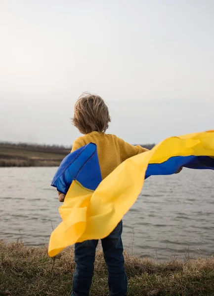 Unrecognizable Boy Stands His Back Shore Lake Fluttering Blue Yellow — стокове фото