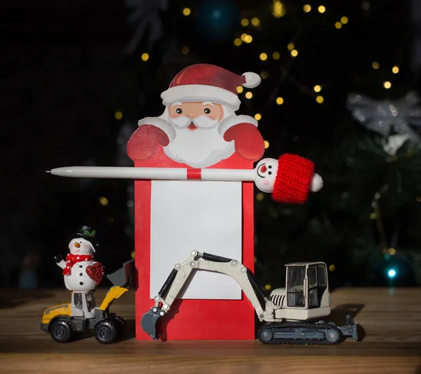 Modellen Van Speelgoed Graafmachines Sneeuwpop Notebook Met Kerstman Pen Achtergrond — Stockfoto