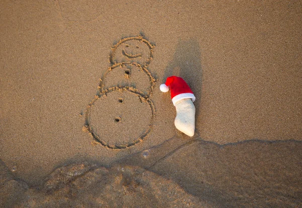 Красная Шляпа Санта Клауса Белом Камне Снеговик Нарисованный Песке Прибрежном — стоковое фото