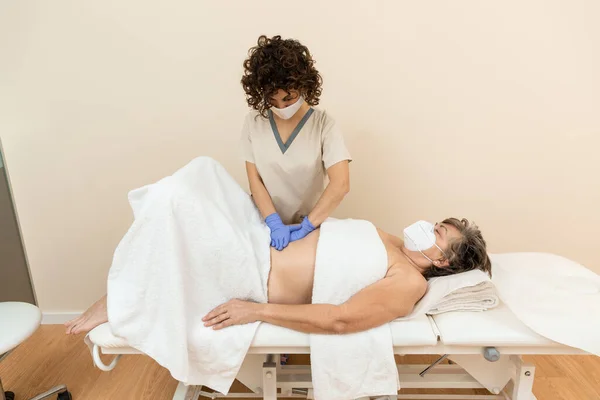 Bir fizyoterapistin olgun bir kadının karnı üzerindeki diastazis rektumunu kontrol etmesi. — Stok fotoğraf