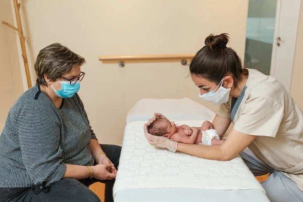 Fisioterapeuta feminina profissional realizando trabalho parietal e sutura lambdoide em um recém-nascido. — Fotografia de Stock