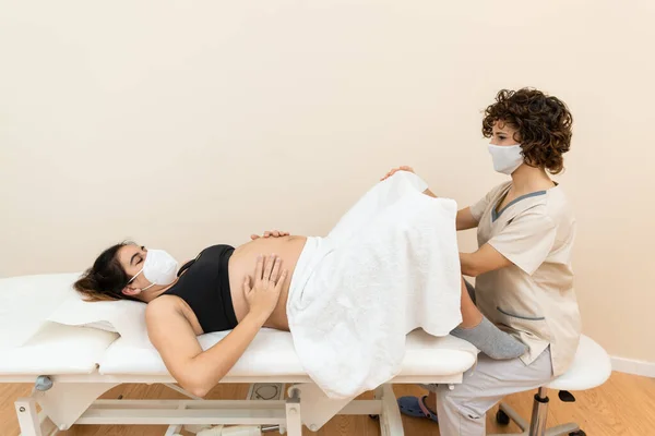 Nőgyógyász vizsgálja és elvégzi a medencetartó kezelés terhes fehér nő — Stock Fotó