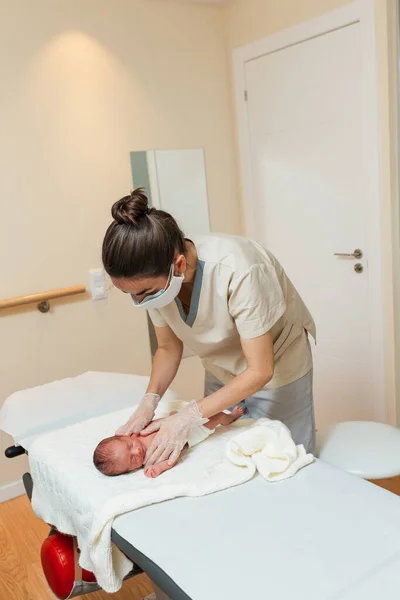 Női fizioterapeuta, aki egy újszülött vállövét értékeli.. — Stock Fotó