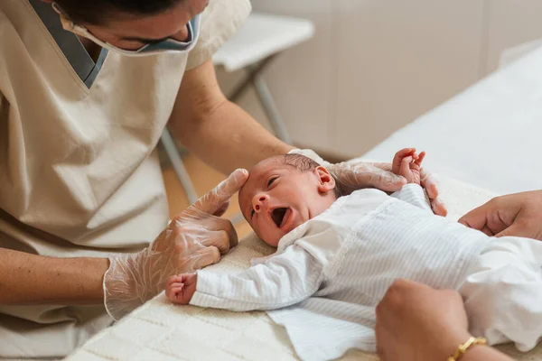 Physiotherapist evaluating the asymmetric tonic reflex in a newborn baby. — Stock Photo, Image