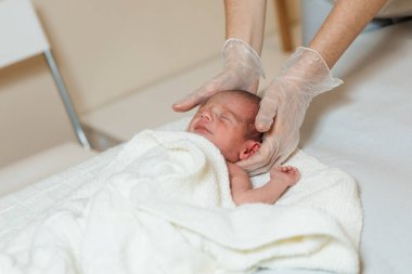 Klinikte yeni doğmuş bir bebekle çalışan profesyonel fizyoterapist..