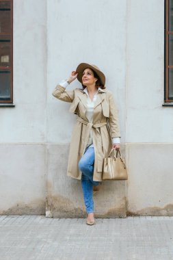 Sokakta poz veren şık, kalın elbiseli bir kadın..