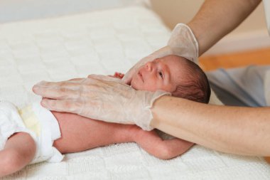 Fizyoterapist yeni doğan bebeğe servikal fasya uyguluyor..
