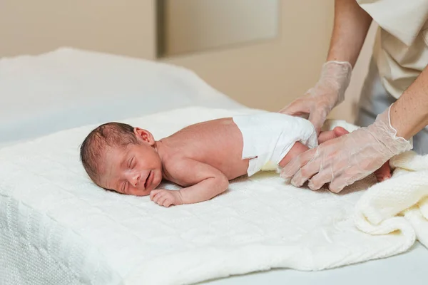 Professional physiotherapist doing an evaluation of the spine of a newborn baby. — Stock Photo, Image