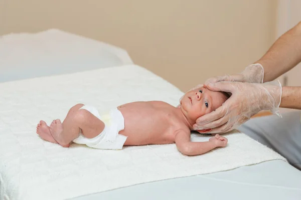 Physiotherapist performing a metopic suture work on a newborn baby in a therapy center. — Stock Photo, Image