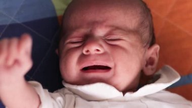 Küçük bir bebeğin yatakta yatarken ağlamasını yakından izle..