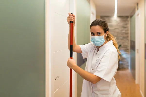 Frau putzt Flur einer Klinik vor laufender Kamera — Stockfoto