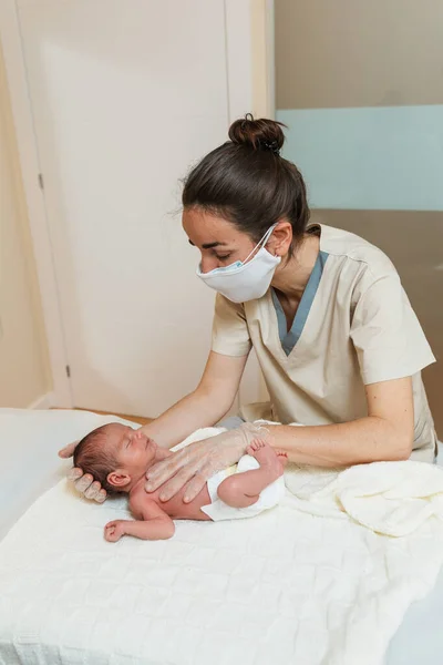 Professional physiotherapist performing mediastinal work on a newborn baby. — Stock Photo, Image