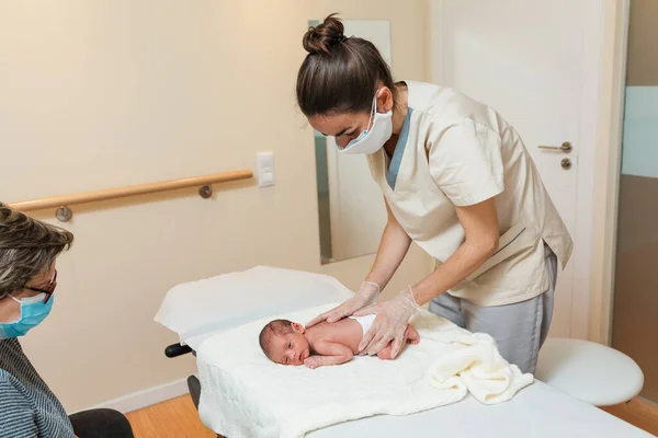Fisioterapeuta feminina fazendo uma avaliação da coluna vertebral de um bebê recém-nascido. — Fotografia de Stock