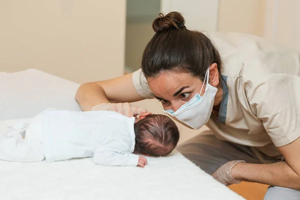 Fizyoterapist, yeni doğmuş bir bebeğe dekübitus yanlısı kas uyarısı yapıyor.. — Stok fotoğraf