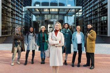 Sokaktaki farklı iş arkadaşlarının yanında mutlu bir iş kadını.