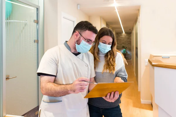 Enfermera explicando notas a paciente femenina en centro de salud — Foto de Stock