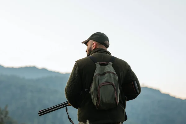 Männliche Jäger beobachten die Natur bei der Suche nach Tieren in hügeligem Gelände — Stockfoto