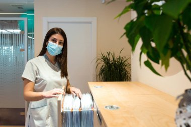 Kameraya bakarken kabine dosyalarını arayan resepsiyonist