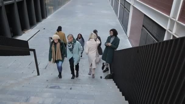 Gente de negocios subiendo y bajando las escaleras en medio de los edificios de oficinas en el distrito financiero. — Vídeos de Stock