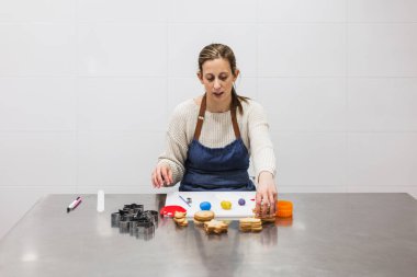 Pasta şefi onları dekore etmek için kurabiye alıyor.