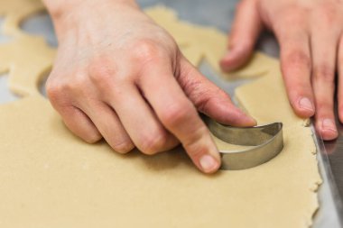 Kurabiye hamuru kesen pasta şefinin yakın görüntüsü.